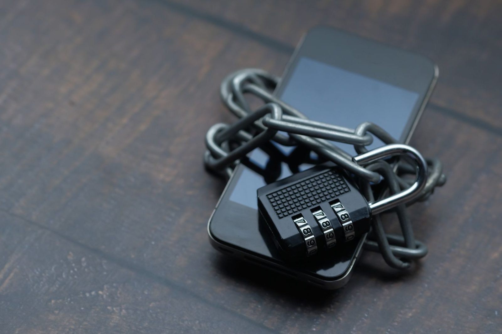 Smartphone envolto por corrente com cadeado, simbolizando proteção de dados