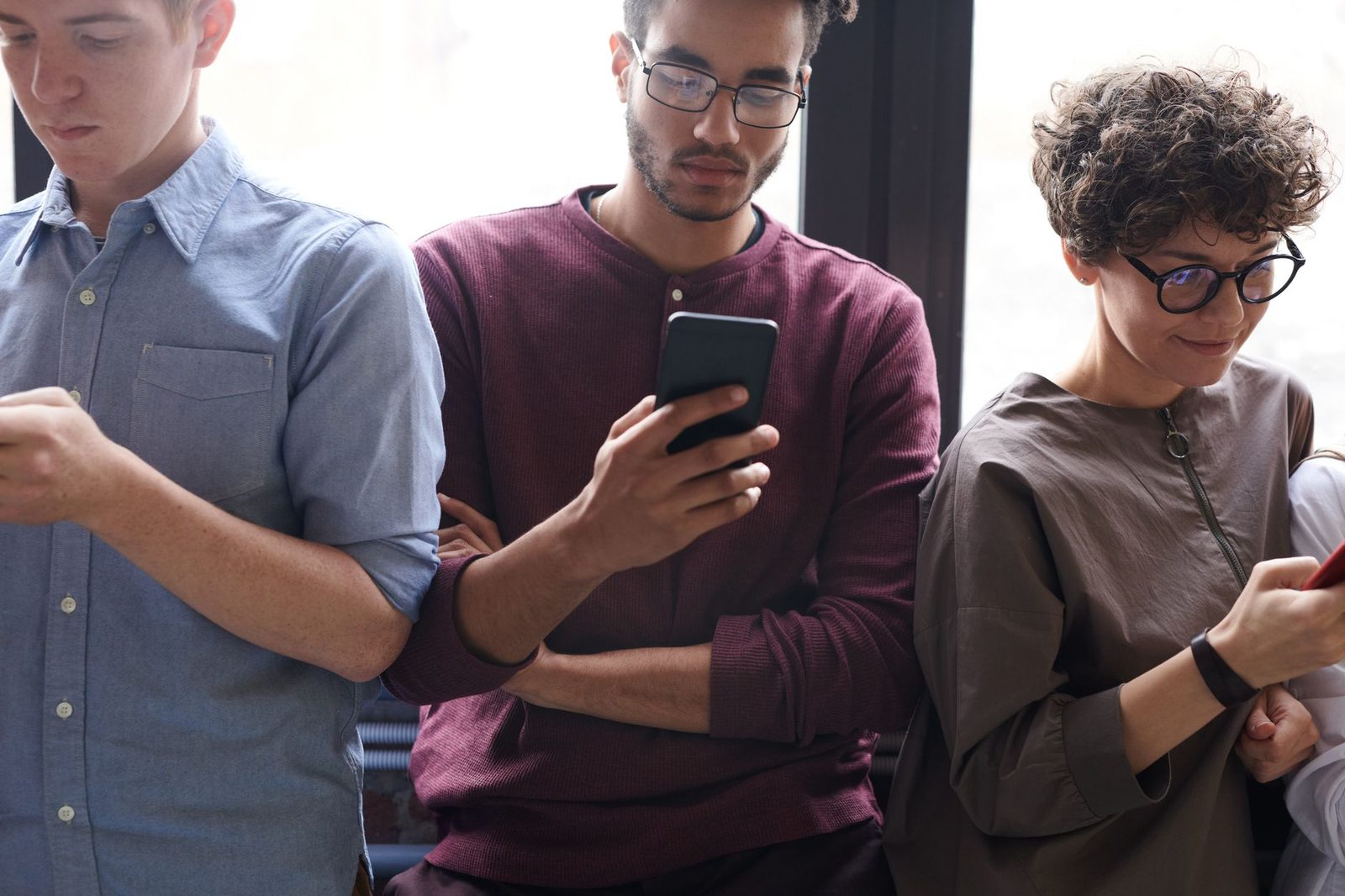 Grupo diverso de pessoas usando smartphones simultaneamente, ilustrando adoção rápida de tecnologia