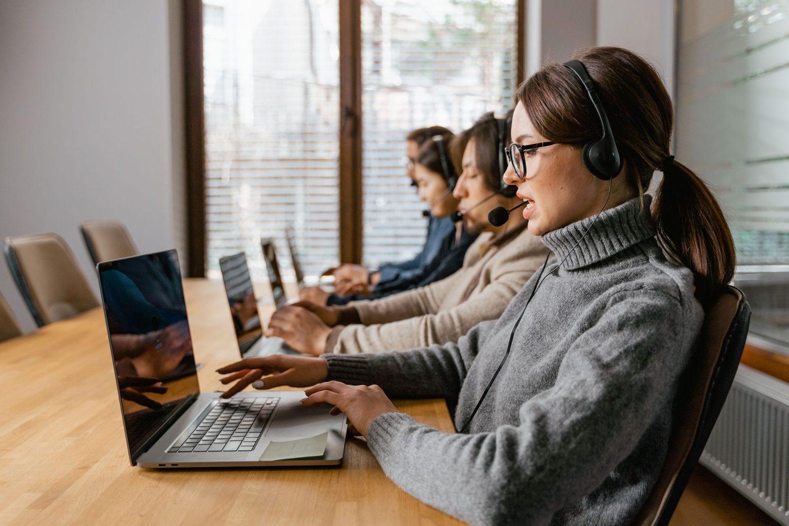 Equipe de atendimento com fones de ouvido respondendo clientes