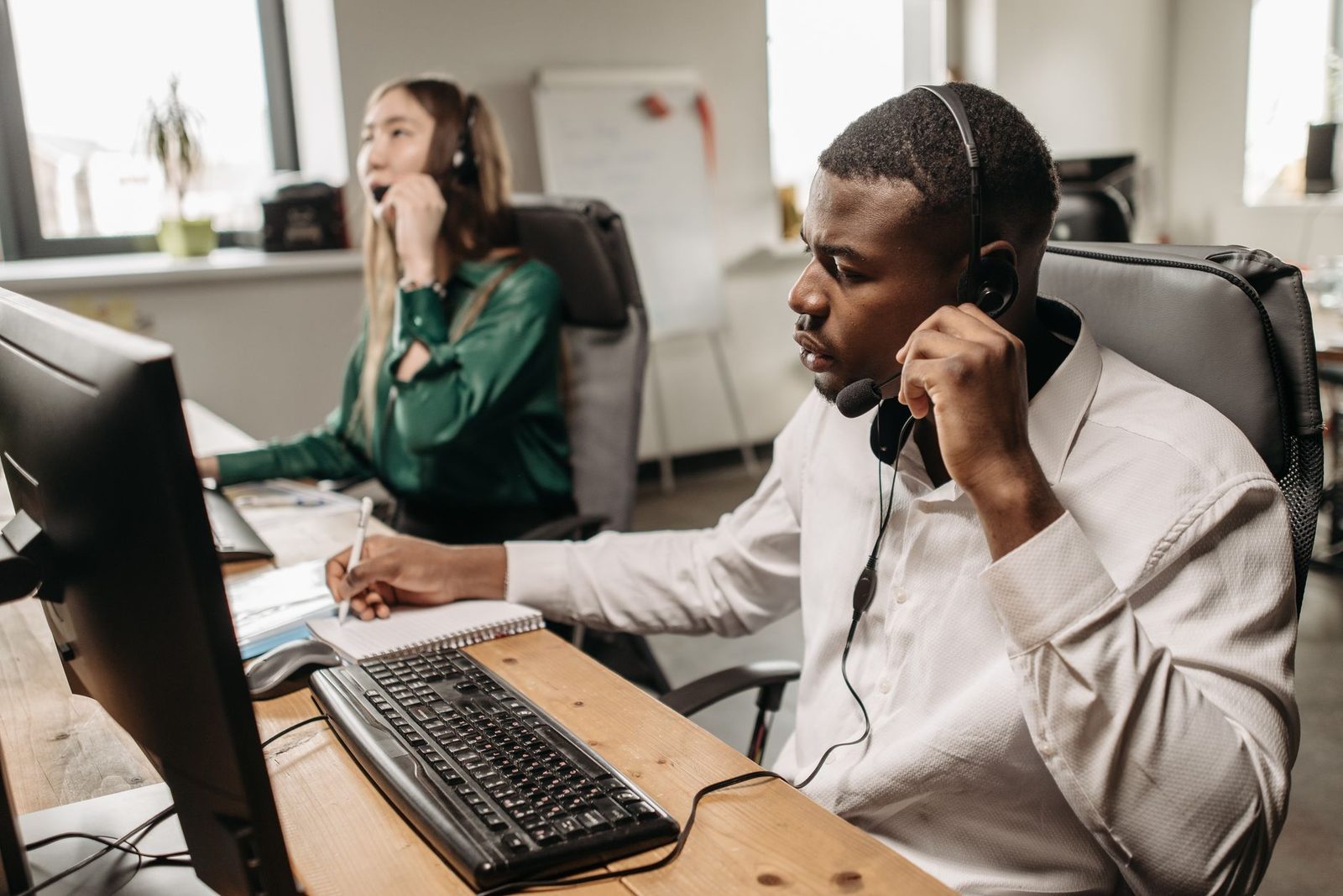 Equipe de atendimento respondendo ligações e mensagens de clientes no escritório