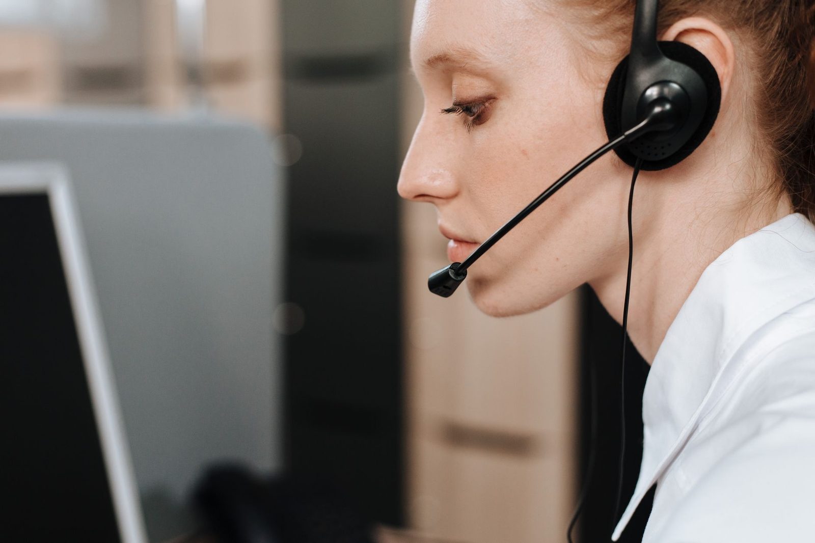 Atendente com headset respondendo clientes no computador