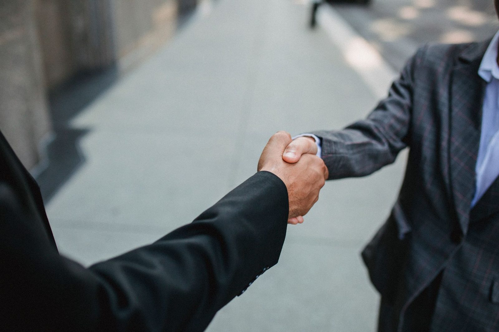 Aperto de mãos entre dois profissionais selando o fechamento de um negócio
