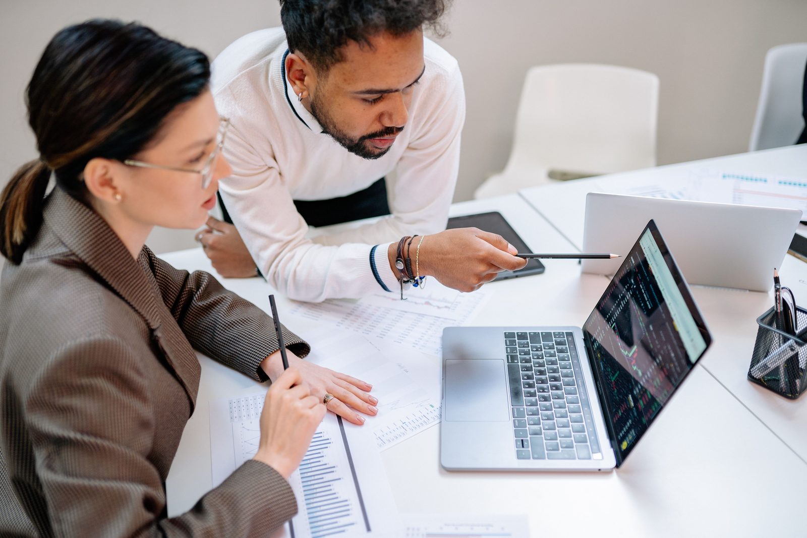 Profissionais analisando dados de desempenho em um laptop