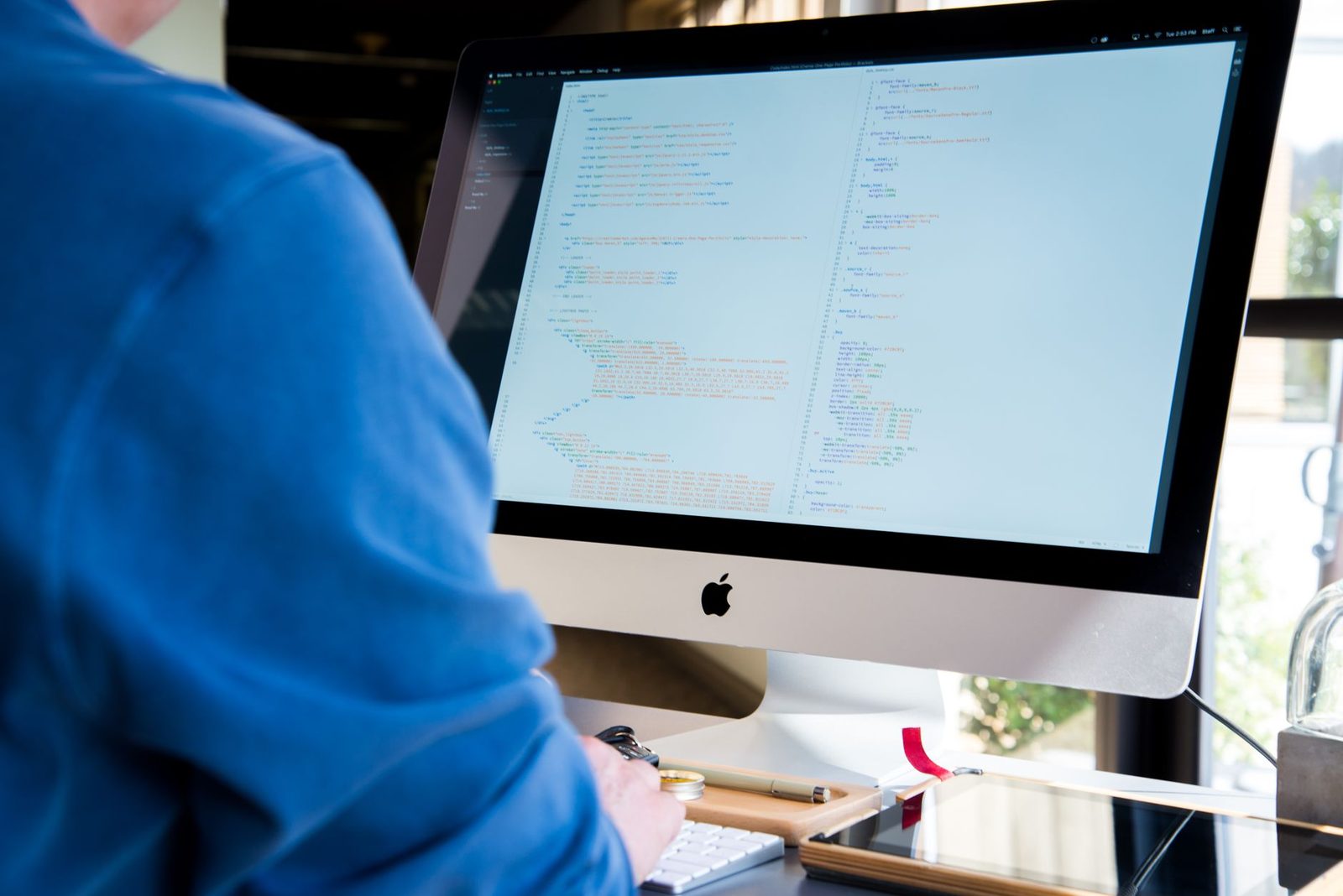 Programador trabalhando em um computador, codificando em uma tela