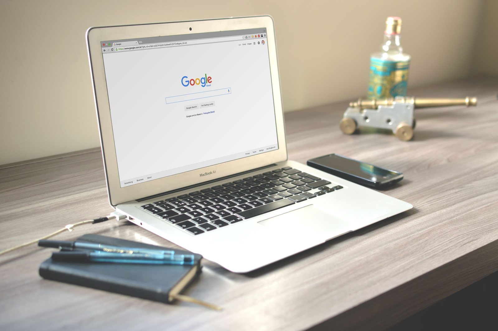 Laptop aberto na página de busca do Google em uma mesa de trabalho