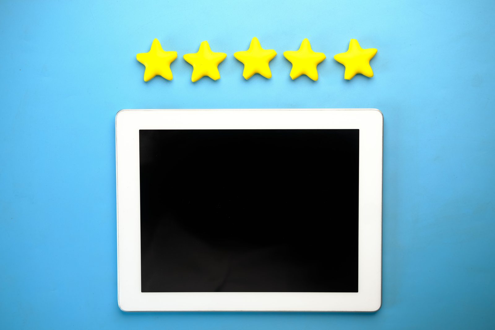 Tablet mostrando cinco estrelas amarelas, representando avaliações de clientes